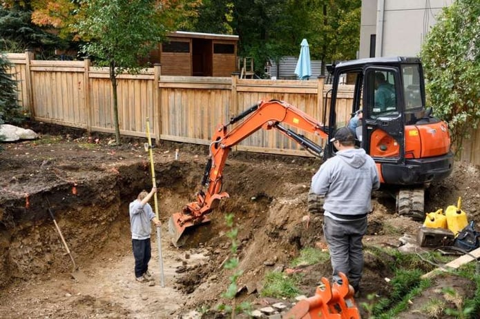 Fiberglass pool builder excavating for a pool in Canada